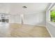 Bright living room featuring hardwood floors, crown molding, and a sliding glass door at 5810 8Th Ave, New Port Richey, FL 34652