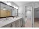 Bathroom featuring double sink vanity with gray cabinets and large mirror reflecting a walk-in closet at 8765 Bardmoor Blvd # 107, Seminole, FL 33777