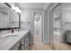 Bathroom with double sink vanity, mirror and view to toilet and bathtub/shower at 8765 Bardmoor Blvd # 107, Seminole, FL 33777