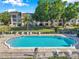 Beautiful community pool surrounded by lounge chairs and lush landscaping at 8765 Bardmoor Blvd # 107, Seminole, FL 33777