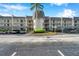 Three-story condo building with private balconies, covered parking, and a well-maintained lawn at 8765 Bardmoor Blvd # 107, Seminole, FL 33777