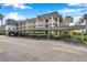 Condo building featuring covered parking and manicured landscaping at 8765 Bardmoor Blvd # 107, Seminole, FL 33777