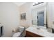 Bright bathroom featuring a single sink vanity, mirror, toilet, and artwork at 903 Pinellas Bayway S # 308, Tierra Verde, FL 33715