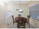 Cozy dining area featuring a wooden table set under a hanging light fixture and bright window at 903 Pinellas Bayway S # 308, Tierra Verde, FL 33715