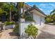 Beautiful home exterior with lush landscaping, a two-car garage, and a decorative address marker at 903 Pinellas Bayway S # 308, Tierra Verde, FL 33715