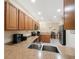 Spacious kitchen with stainless steel appliances, wood cabinets, and adjacent dining area at 903 Pinellas Bayway S # 308, Tierra Verde, FL 33715