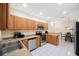 Modern kitchen with stainless steel appliances, ample wood cabinets, and a view to the dining area at 903 Pinellas Bayway S # 308, Tierra Verde, FL 33715