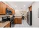 Bright kitchen features wooden cabinets, stainless steel appliances, and an adjacent dining area at 903 Pinellas Bayway S # 308, Tierra Verde, FL 33715