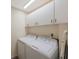 The laundry room features a washer and dryer, overhead cabinets, and an ironing board at 903 Pinellas Bayway S # 308, Tierra Verde, FL 33715