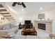 Bright living room featuring tile floors, a fireplace, a ceiling fan, and staircase access at 903 Pinellas Bayway S # 308, Tierra Verde, FL 33715