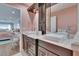Bathroom featuring a double sink vanity, large mirror, modern lighting and view into the bedroom at 100 Bluff View Dr # 510A, Belleair Bluffs, FL 33770
