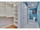 View into the bathroom and closet with blue walls and walk-in shower at 100 Bluff View Dr # 510A, Belleair Bluffs, FL 33770