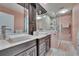 Bathroom featuring a double sink vanity, an enclosed shower and a heated towel rack at 100 Bluff View Dr # 510A, Belleair Bluffs, FL 33770