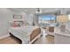 Bright bedroom featuring two beds, ceiling fan, and a large window with water view at 100 Bluff View Dr # 510A, Belleair Bluffs, FL 33770