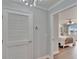 Hallway view to bedroom with white door, chandelier, and light grey walls at 100 Bluff View Dr # 510A, Belleair Bluffs, FL 33770