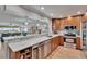 Open kitchen with marble countertops, stainless steel appliances, and bar seating to living area at 100 Bluff View Dr # 510A, Belleair Bluffs, FL 33770