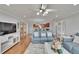 Open-concept living area featuring hardwood floors, comfortable seating, ceiling fan and view into the modern kitchen at 100 Bluff View Dr # 510A, Belleair Bluffs, FL 33770