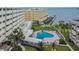 Aerial view showcases a community pool with lounge chairs surrounded by landscaping and waterfront scenery at 100 Bluff View Dr # 510A, Belleair Bluffs, FL 33770