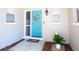Inviting blue front door adorned with a wreath, flanked by windows and a potted plant at 10035 82Nd St, Seminole, FL 33777