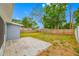 Spacious backyard with a patio area, lush green grass, mature trees, and a wood fence at 1113 53Rd S St, Gulfport, FL 33707
