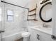 Bathroom with white tile tub surround, modern fixtures, and open shelving at 1113 53Rd S St, Gulfport, FL 33707