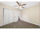 Bedroom featuring gray wood-look floors, a ceiling fan, and white closet doors at 1113 53Rd S St, Gulfport, FL 33707
