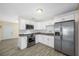Kitchen with stainless steel appliances, white cabinets, granite countertops and wood-look tile floors at 1113 53Rd S St, Gulfport, FL 33707