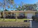 Charming single-story home with a well-maintained lawn, mature trees, and a convenient attached garage at 1125 Engman St, Clearwater, FL 33755