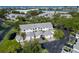 An aerial view of charming townhouses with garages, lush landscaping, and water views in the distance at 11520 Shipwatch Dr # 1385, Largo, FL 33774