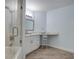Bathroom with glass enclosed shower-tub combo, white vanity with countertop, makeup mirror, and wood floors at 11520 Shipwatch Dr # 1385, Largo, FL 33774