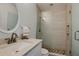 Modern bathroom featuring a stand up shower and vanity with a stylish round mirror at 11520 Shipwatch Dr # 1385, Largo, FL 33774