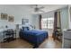 Cozy bedroom featuring a large window, ceiling fan, and neutral-toned walls and blue bedding at 11520 Shipwatch Dr # 1385, Largo, FL 33774