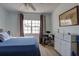 Sunlit bedroom featuring a map, a white dresser, musical instruments and a large window at 11520 Shipwatch Dr # 1385, Largo, FL 33774