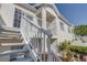 Exterior of the house showing white wooden stairways and a balcony in a lush tropical garden at 11520 Shipwatch Dr # 1385, Largo, FL 33774