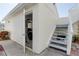 Exterior view of a garage with an open door, car inside, and staircase to the side at 11520 Shipwatch Dr # 1385, Largo, FL 33774
