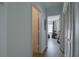 Hallway with wood floors leading to a bedroom with window and closet with paneled doors at 11520 Shipwatch Dr # 1385, Largo, FL 33774