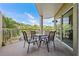 Balcony features seating area overlooking lush tropical greenery and blue skies at 11605 Gulf Blvd # 203, Treasure Island, FL 33706