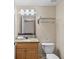 Cozy bathroom with a wooden vanity, granite countertop, and a framed mirror at 11605 Gulf Blvd # 203, Treasure Island, FL 33706