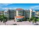 Beautiful multi-story condo building near the beach with a circular driveway, lush landscaping, and ample parking at 11605 Gulf Blvd # 203, Treasure Island, FL 33706
