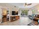 Bright living room featuring tile floors, balcony access, and a comfortable leather sofa at 11605 Gulf Blvd # 203, Treasure Island, FL 33706