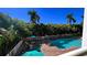 Condo pool area featuring a spa surrounded by tropical foliage at 11605 Gulf Blvd # 203, Treasure Island, FL 33706