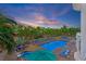 Bright, beautiful pool area featuring lounge chairs, tables, umbrellas, and a jacuzzi with lush tropical landscaping at 11605 Gulf Blvd # 203, Treasure Island, FL 33706