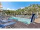 Beautiful pool area surrounded by lush palm trees and lounge chairs on a sunny day at 11605 Gulf Blvd # 203, Treasure Island, FL 33706