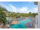 A bright and sunny outdoor pool area surrounded by palm trees and lounge chairs at 11605 Gulf Blvd # 203, Treasure Island, FL 33706