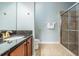 Bathroom featuring granite countertop, wooden cabinets and framed glass shower at 12107 Rambling Stream Dr, Riverview, FL 33569
