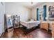 Sunlit bedroom featuring hardwood floors, mirrored wall decor, and modern bookshelves at 12107 Rambling Stream Dr, Riverview, FL 33569