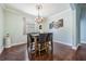 Dining room with hardwood floors, modern chandelier, and an outdoor view through the window at 12107 Rambling Stream Dr, Riverview, FL 33569