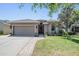 Charming home with well-maintained landscaping, a covered entryway, and an attached two-car garage at 12107 Rambling Stream Dr, Riverview, FL 33569