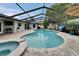 Screened-in pool featuring a spa, a sitting area, and a lush tropical backyard at 1213 Callista Ave, Valrico, FL 33596