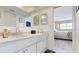Well-lit bathroom vanity with granite countertops, white cabinetry, and an open-concept bedroom at 12405 3Rd E St # 306, Treasure Island, FL 33706